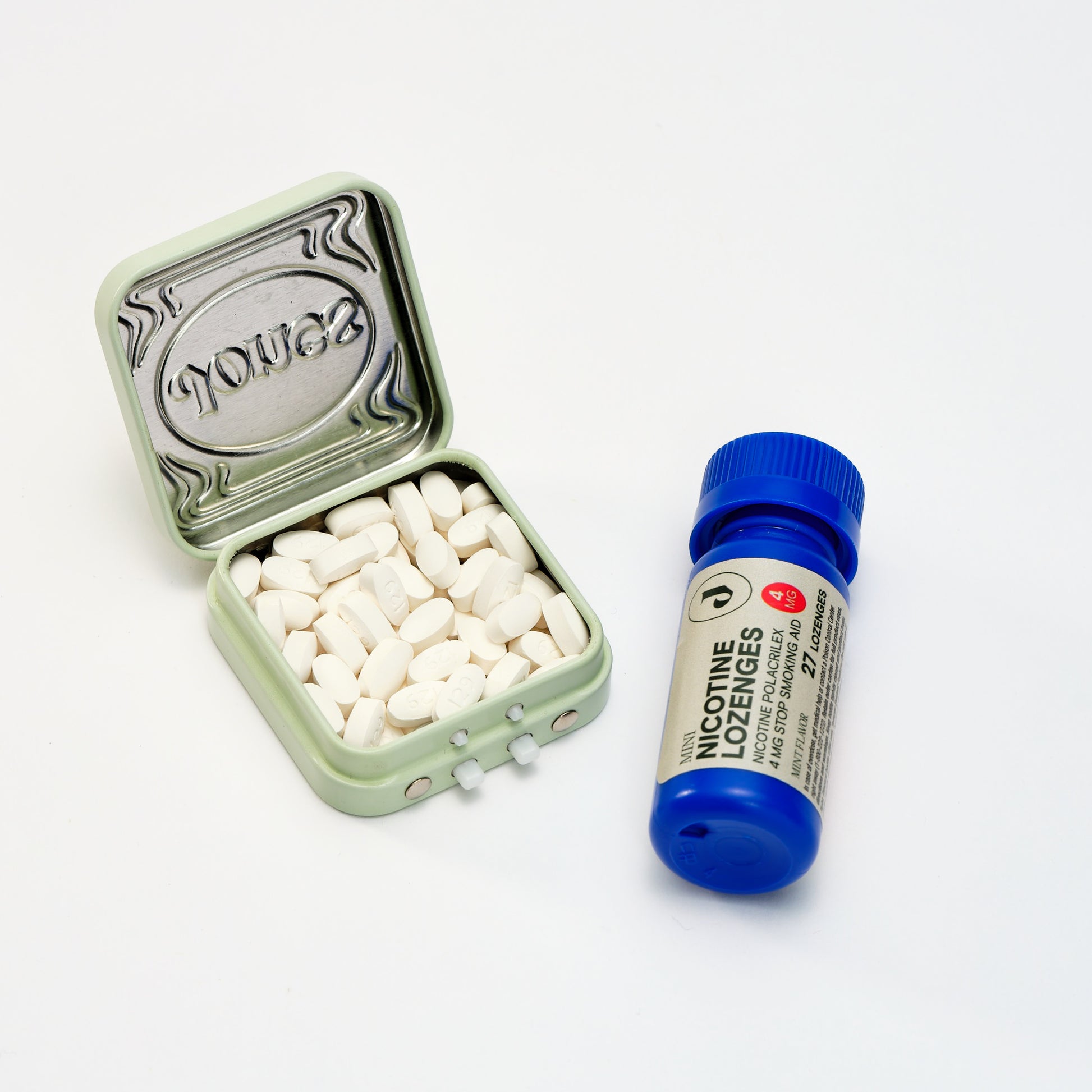 An open tin of loose white lozenges sits next to a closed blue bottle labeled as FDA-approved 4mg Nicotine Lozenge on a white surface, ideal for nicotine replacement therapy.