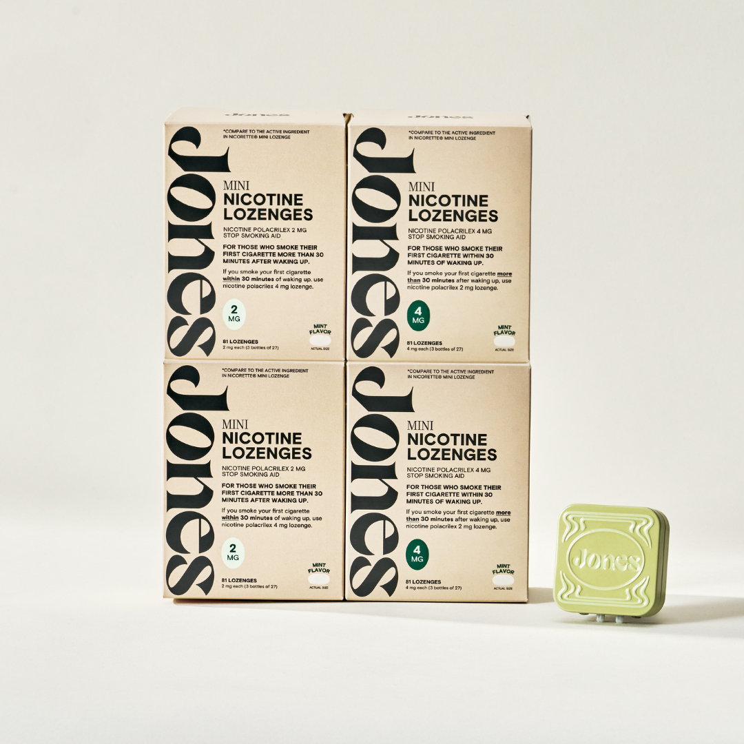 Five beige boxes of Jones Low Dependency Quit Kit are stacked in a pyramid, topped by a pale green tin embossed with "Jones." The arrangement sits against a plain, well-lit background.