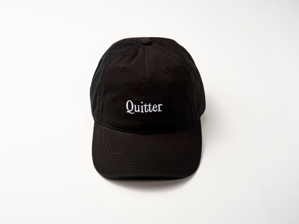 Black cotton twill Quitter Cap from Quit with Jones with "Quitter" embroidered in striking white on the front.