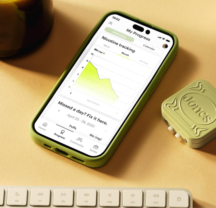 phone on desk with keyboard with screen displaying jones nicotine tracking 