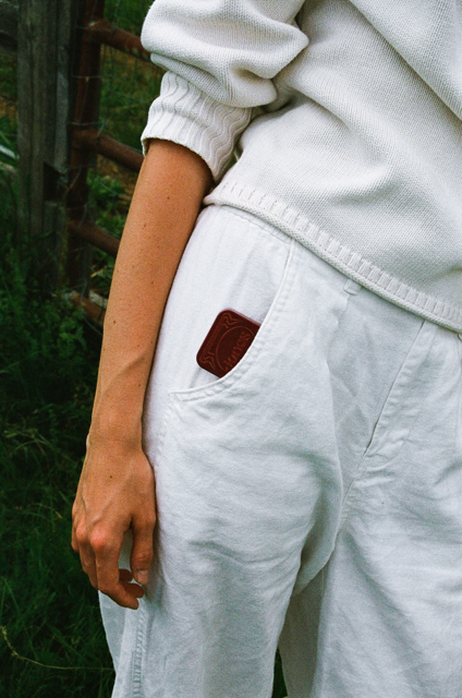 woman in white clothing with cherry jones tin in pocket