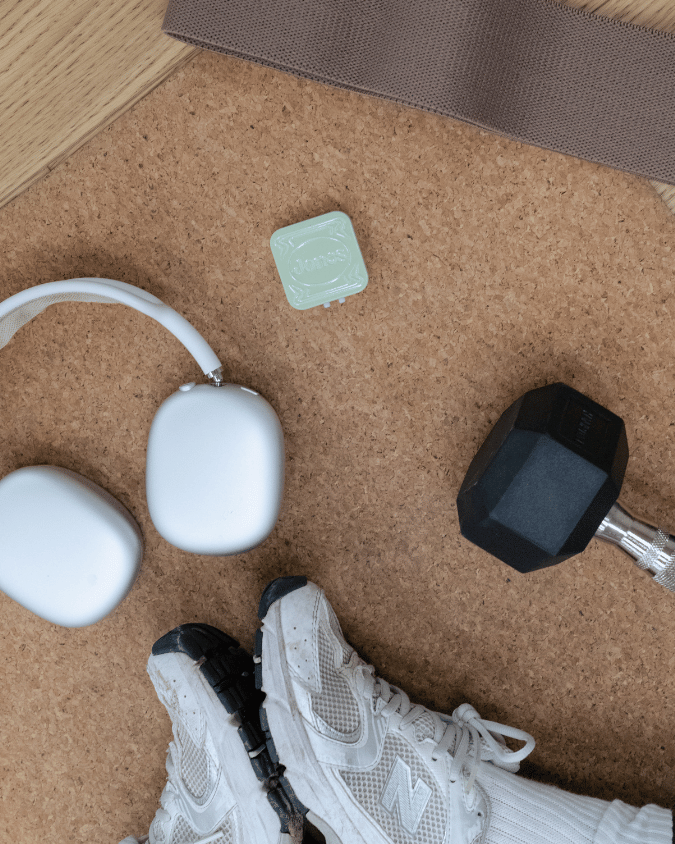 workout mat with dumbbell, headphones, jones tin, and sneakers