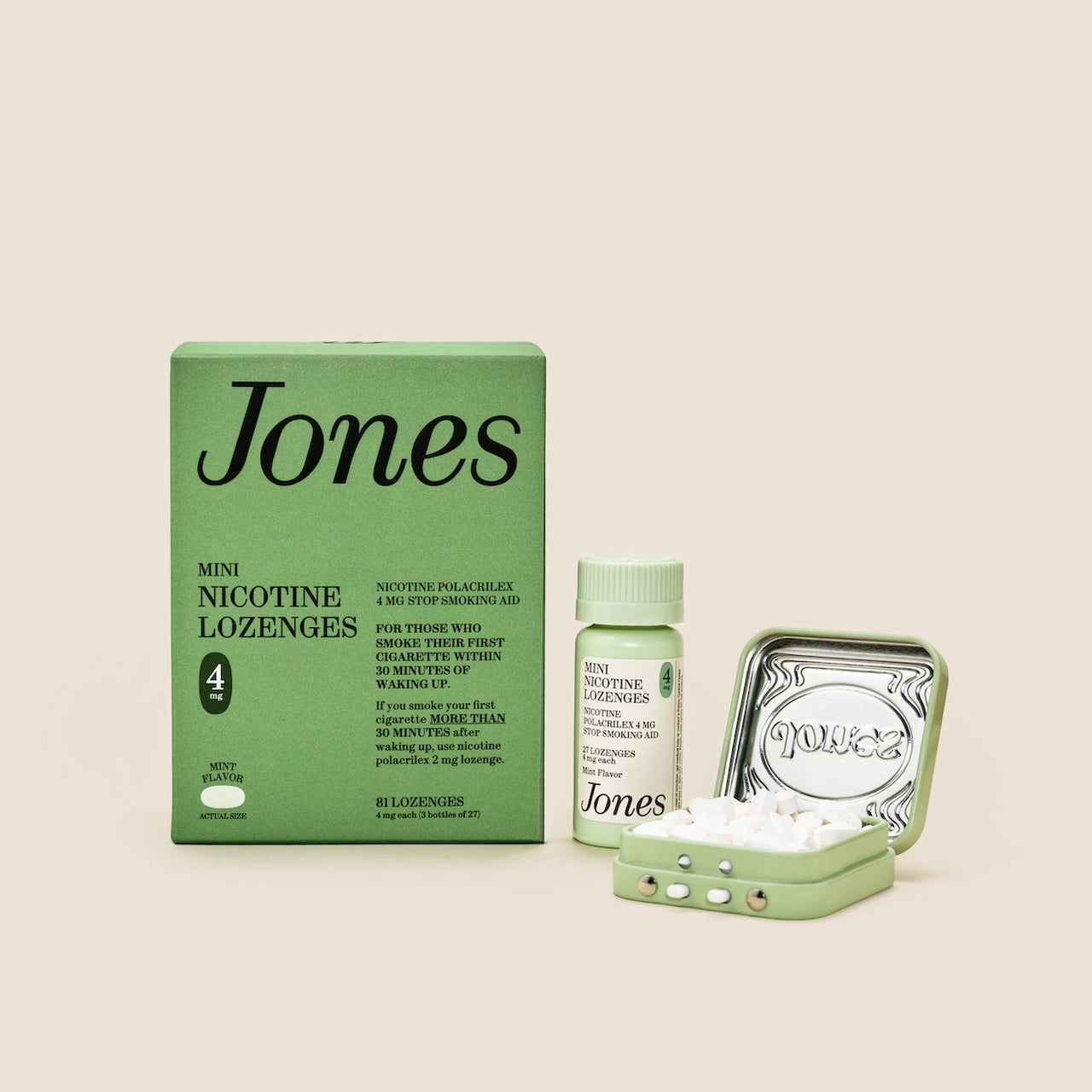Five green boxes labeled "Jones Habit Kicker" are stacked geometrically on a beige background. Three white lozenges, part of this nicotine quit kit, are displayed in front. The boxes have minimalist text and icons.
