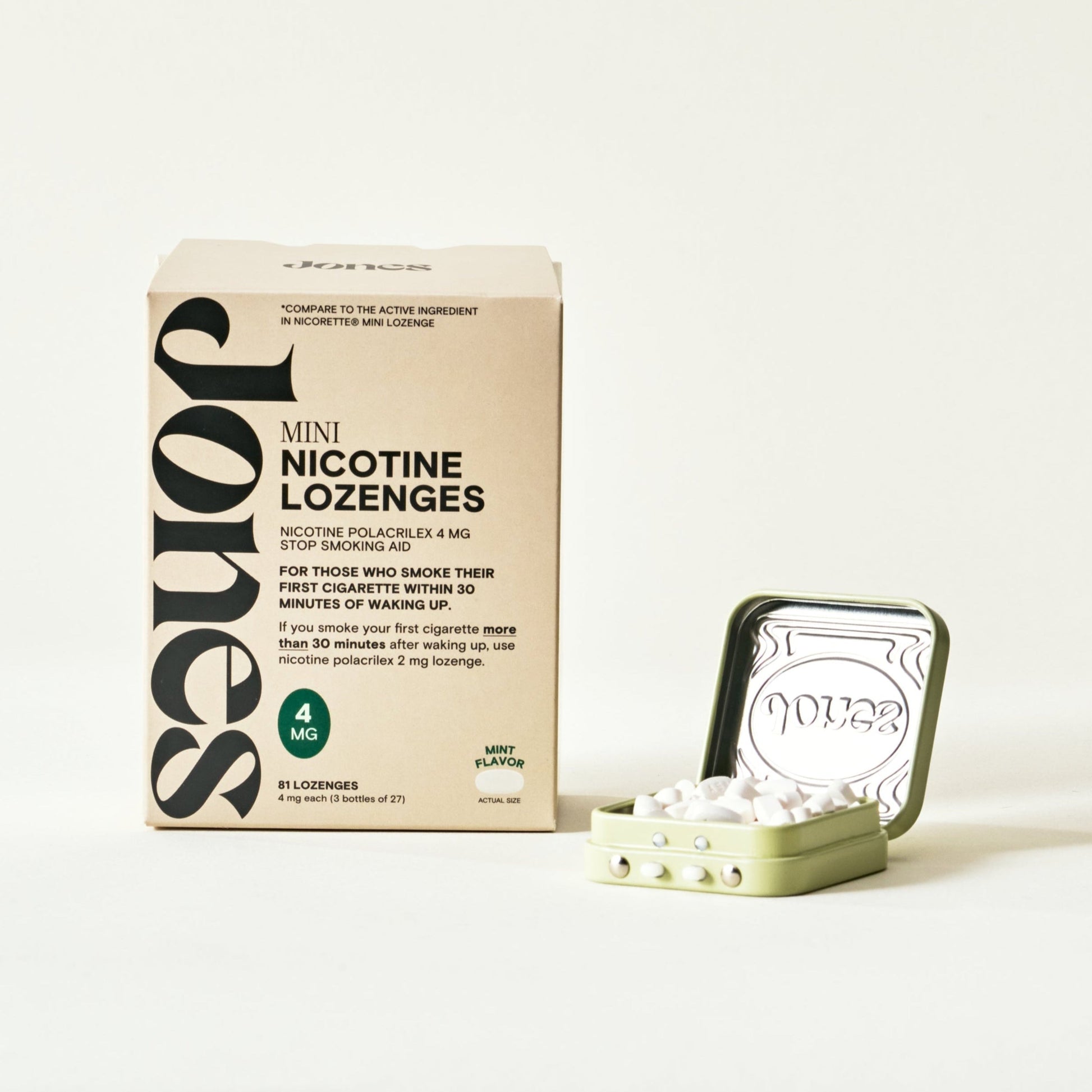 A beige "Quit with Jones 4mg Nicotine Mint" box stands by an open green tin filled with white lozenges. The box shows it's a mint-flavored nicotine replacement therapy product from Quit with Jones, containing 4mg strength lozenges.