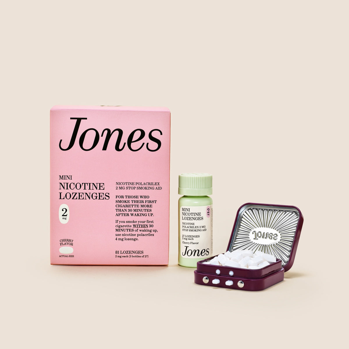 Five green boxes labeled "Jones Habit Kicker" are stacked geometrically on a beige background. Three white lozenges, part of this nicotine quit kit, are displayed in front. The boxes have minimalist text and icons.