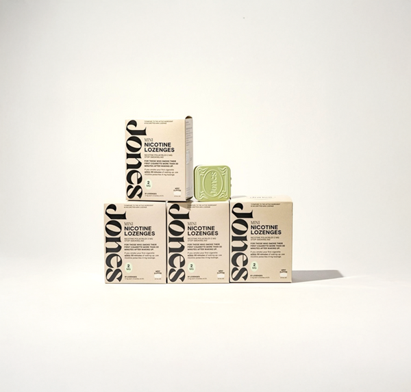 Two tan-colored Jones Sampler boxes are shown—one upright with a green lozenge container on top, the other leaning beside it. Text highlights the Jones brand name, 2mg nicotine mints, and mint flavor.