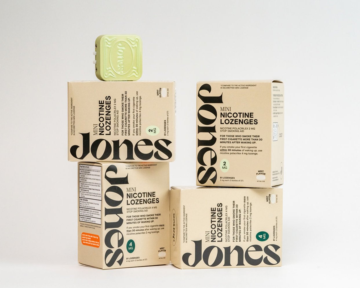 Four boxes of Jones Habit Kicker Mini Nicotine Lozenges, perfect for quit plans, are stacked against a light background with a green lozenge on top. The packaging includes detailed product information.