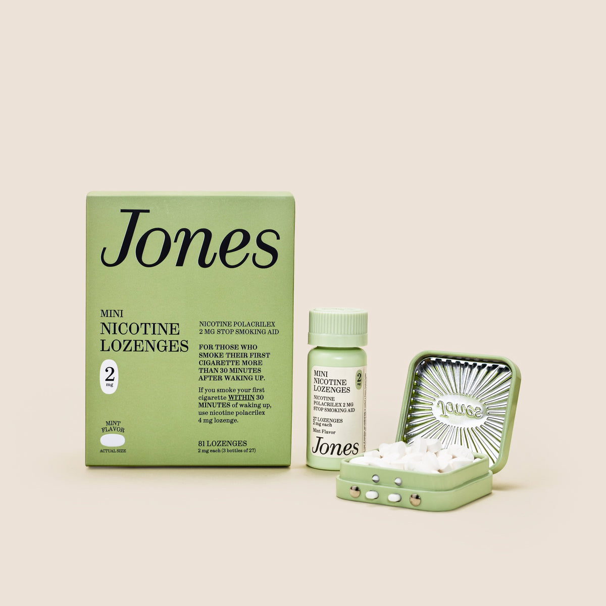 Five green boxes labeled "Jones Habit Kicker" are stacked geometrically on a beige background. Three white lozenges, part of this nicotine quit kit, are displayed in front. The boxes have minimalist text and icons.