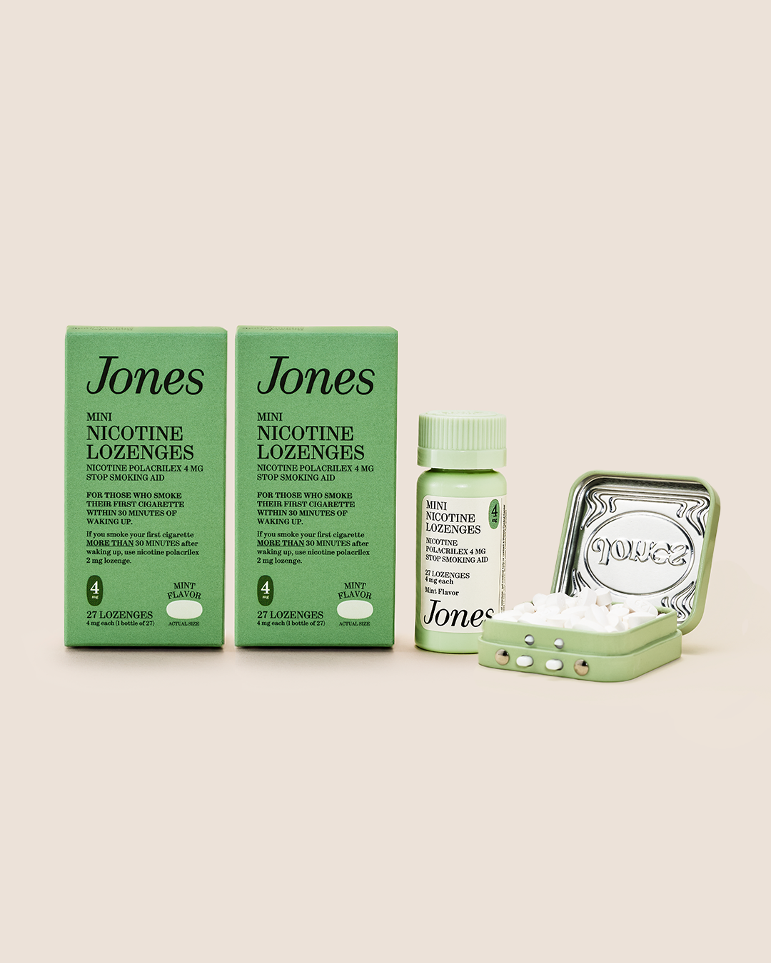 Two green Quit with Jones Kickstart Kit boxes stand side by side—your essentials for a fresh start. Next is a small green bottle, and an open silver tin with white lozenges inside, reminiscent of classic Jones Mints. All items are neatly arranged on a beige background.